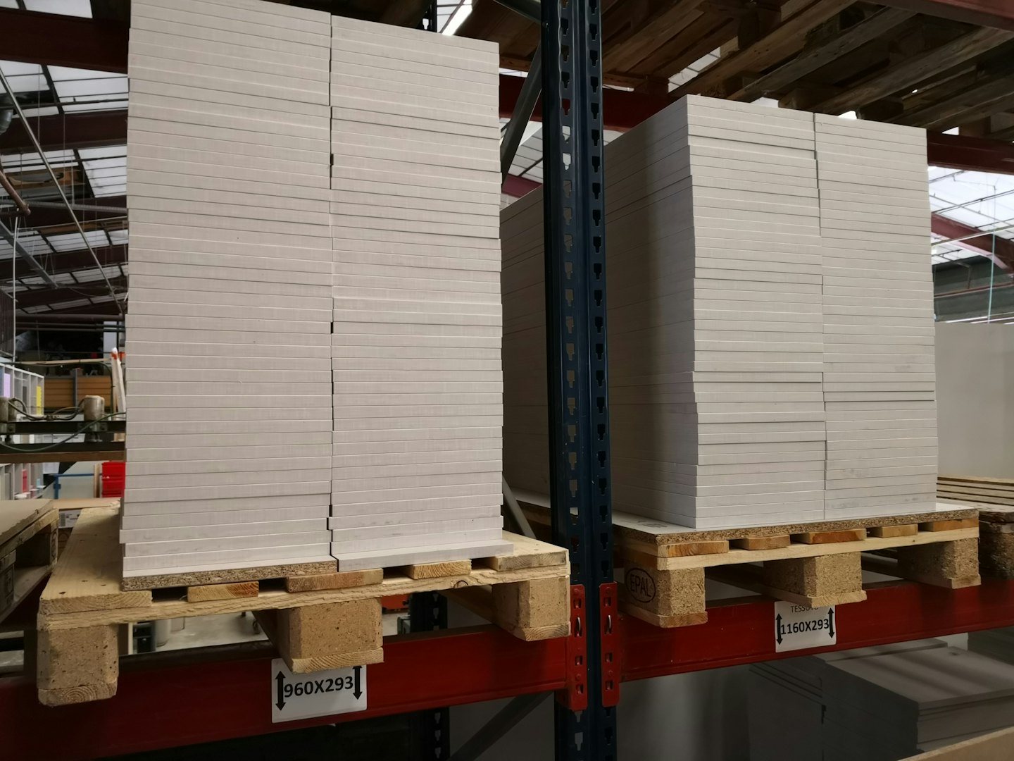 Rectangular panels stacked on industrial shelving in a warehouse.